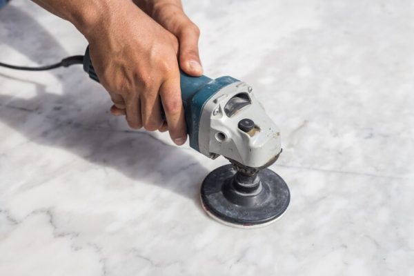 man-polishing-marble-stone-table-by-small-angle-grinder_30478-699